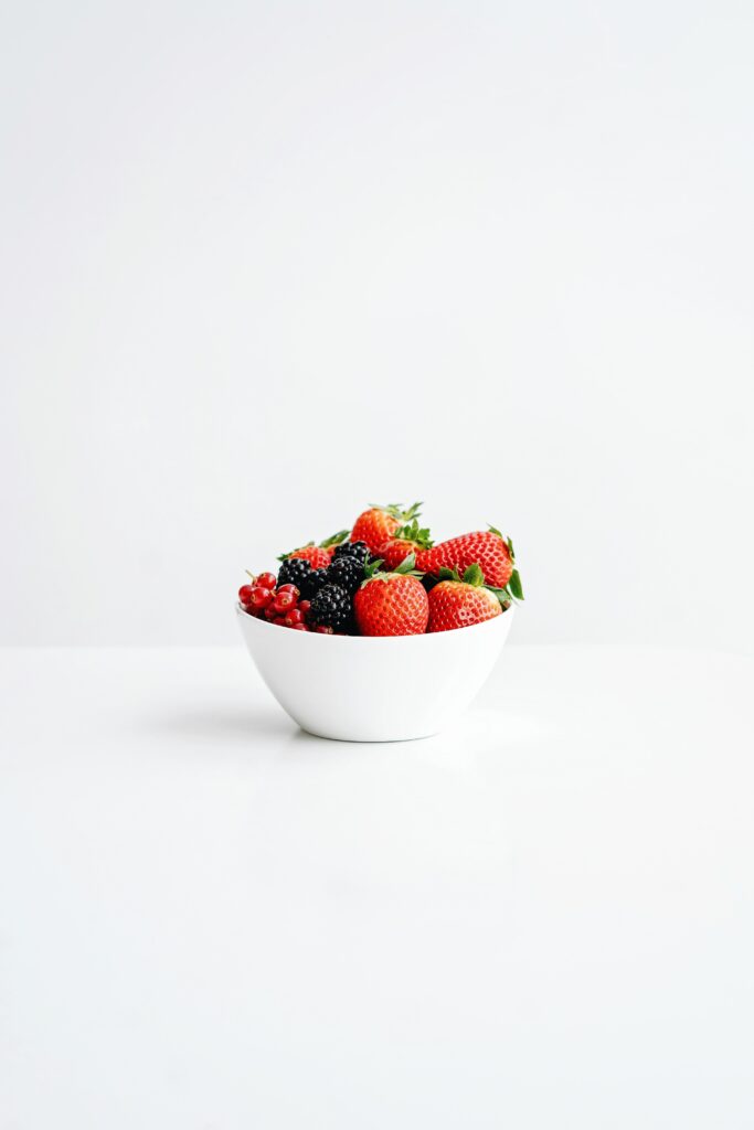 White bowl of strawberries, blackberries, and red currants.